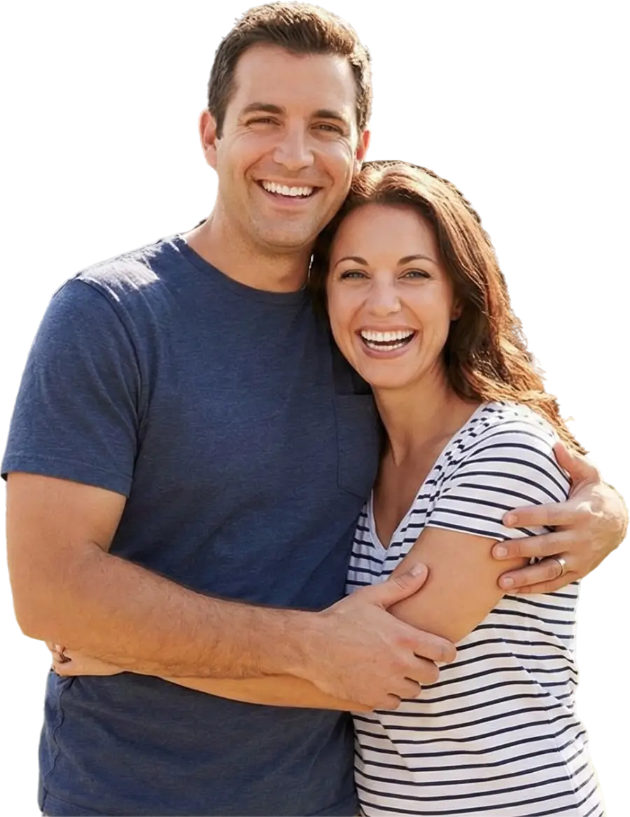 Smiling husband and wife hugging against a gray background, illustrating a stress-free experience with Heritage Homebuyers.